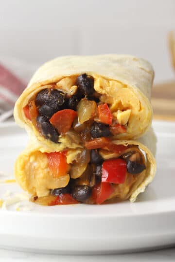 Black bean breakfast burrito sliced in half and stacked to show filling.