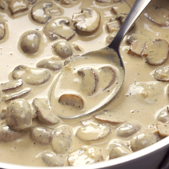 Creamy mushroom sauce in a saute pan with a spoon.