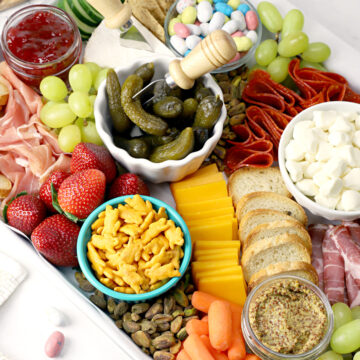 Meats, cheeses, crackers, and fruits set up on an Easter charcuterie board.
