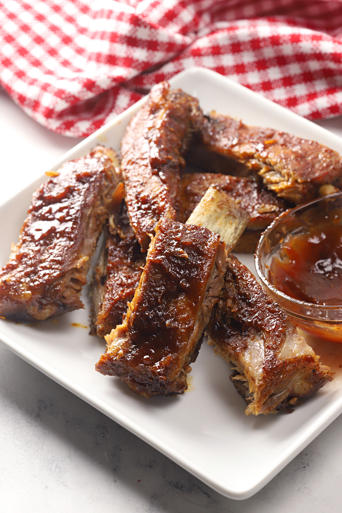 Oven baked ribs on a white plate.