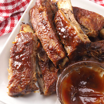 Ribs with a bowl of barbecue sauce.