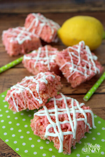 Pink rice krispies treats drizzled in white chocolate.