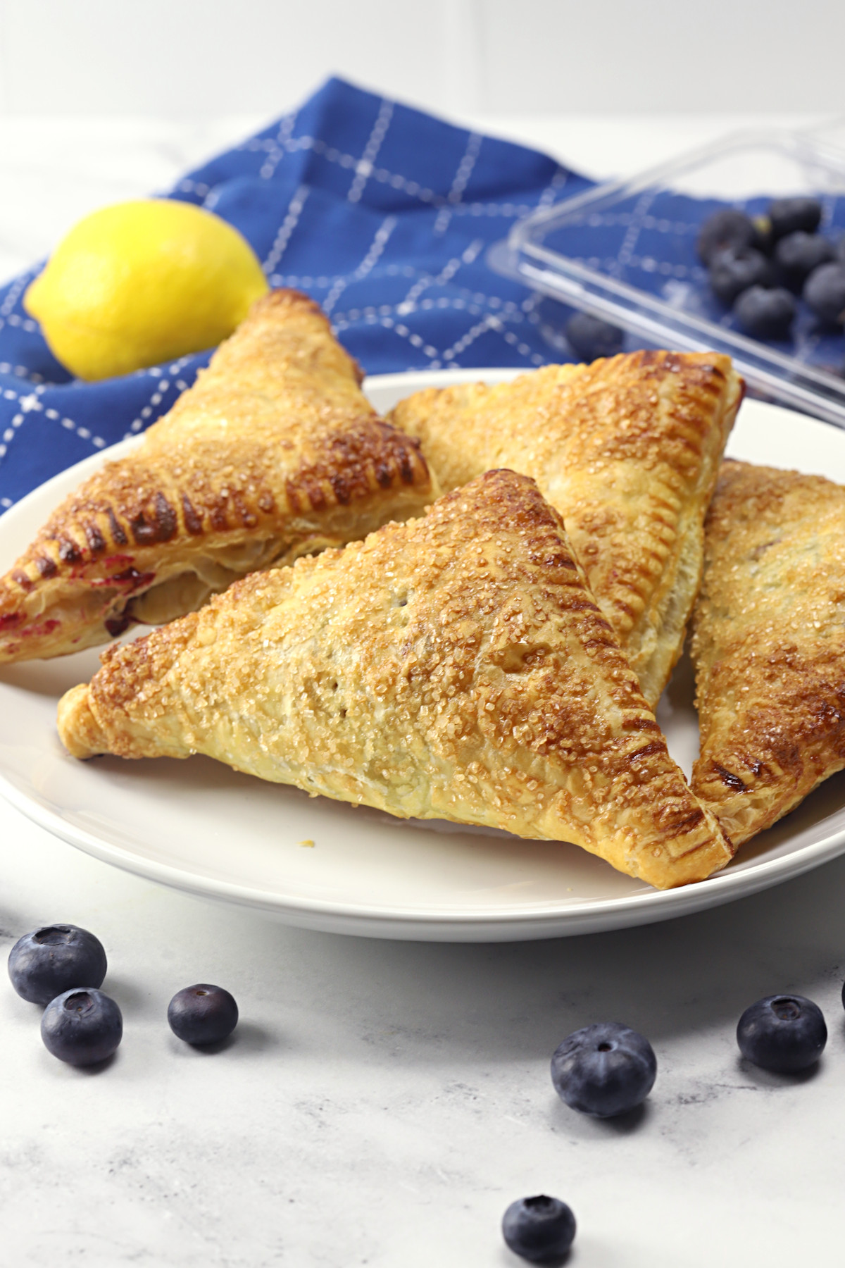 A white plate filled with blueberry turnovers.