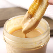 Dipping fries in a jar of burger sauce.