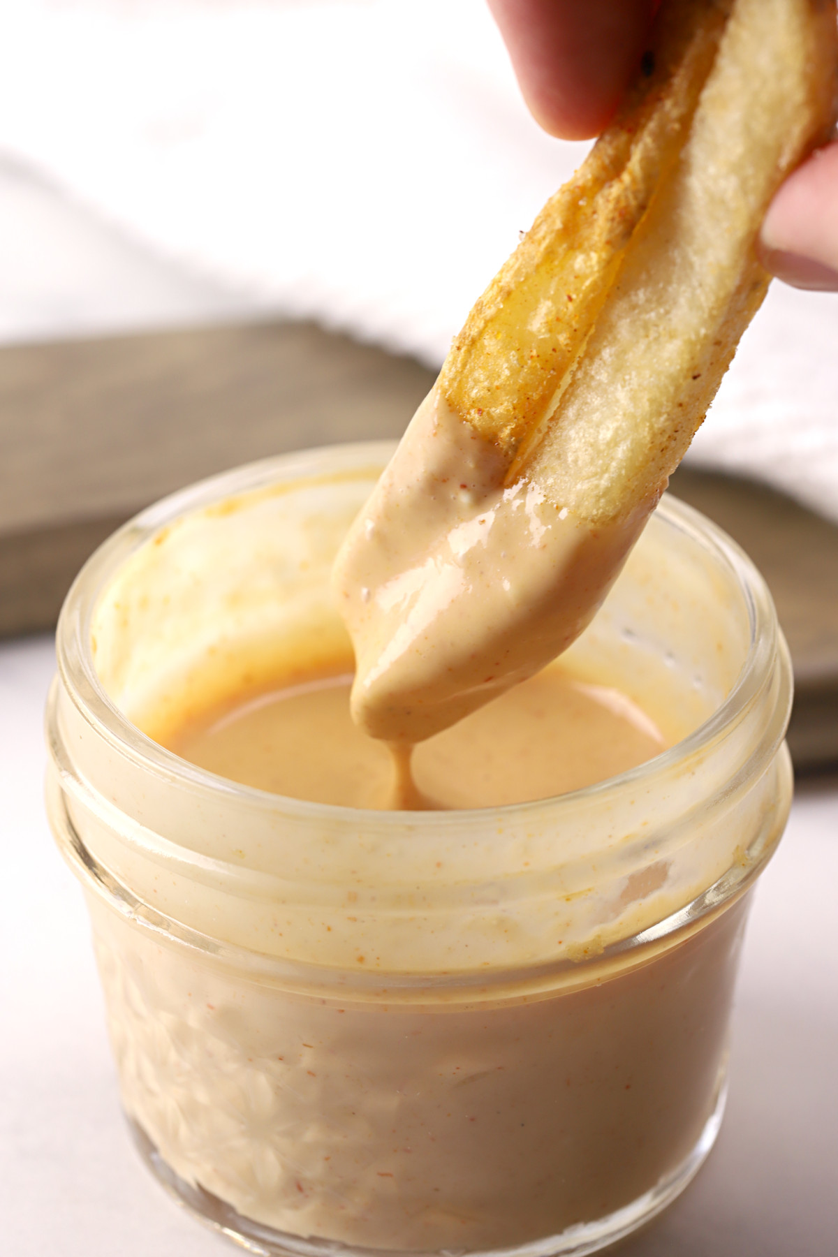 Dipping fries in a jar of burger sauce.