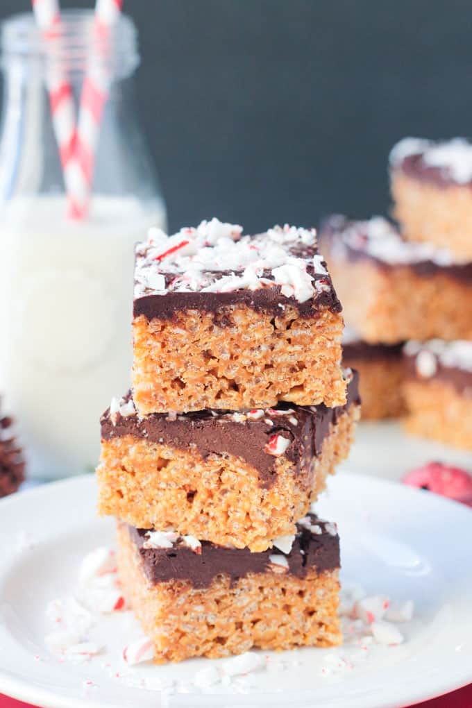A stack of treats topped with candy canes on a plate.