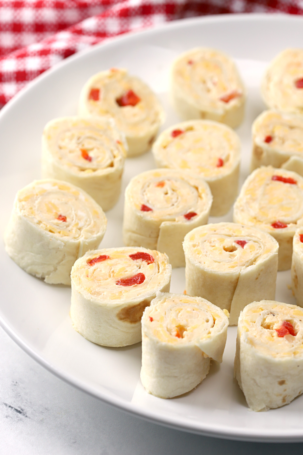 White plate filled with pimento cheese pinwheels.