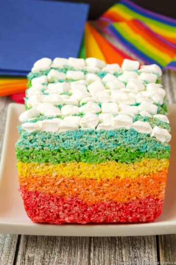 A rainbow rice krispies cake topped with marshmallows.