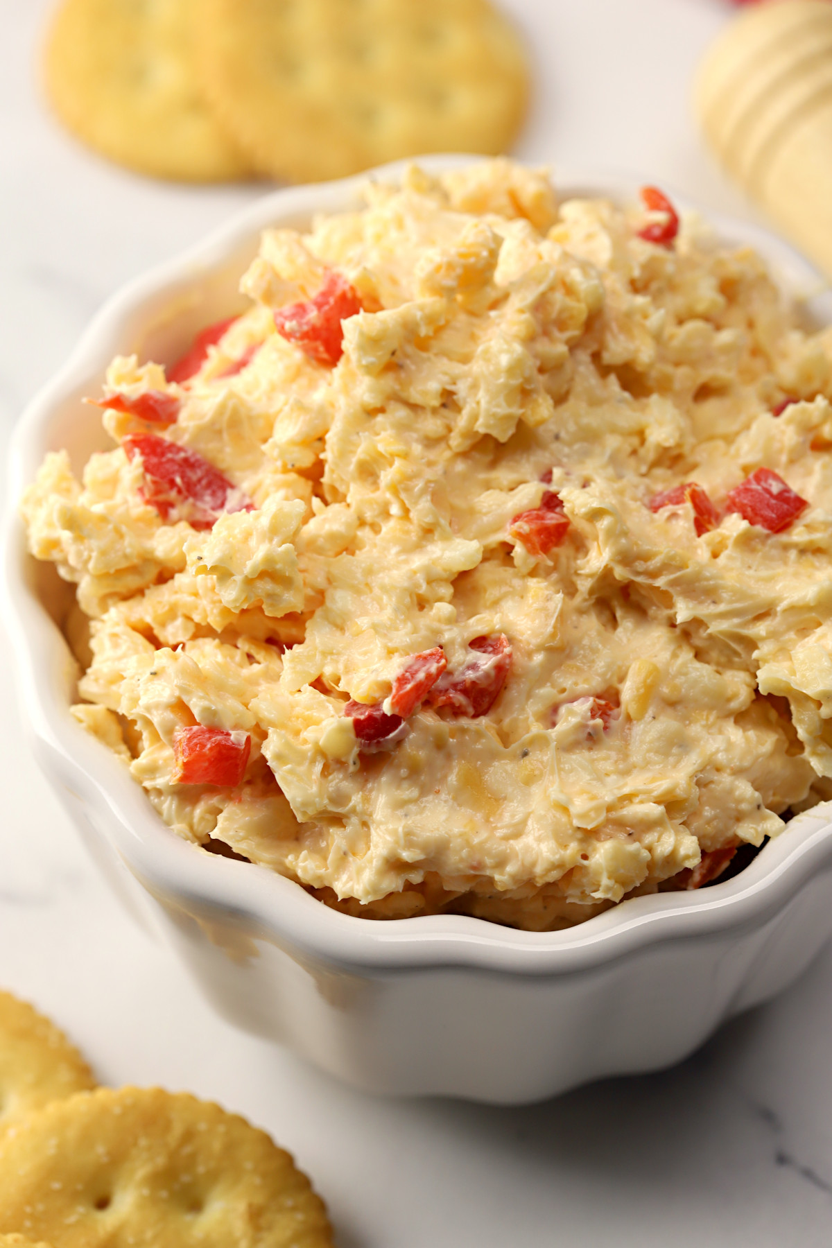 Scalloped bowl filled with pimento cheese.