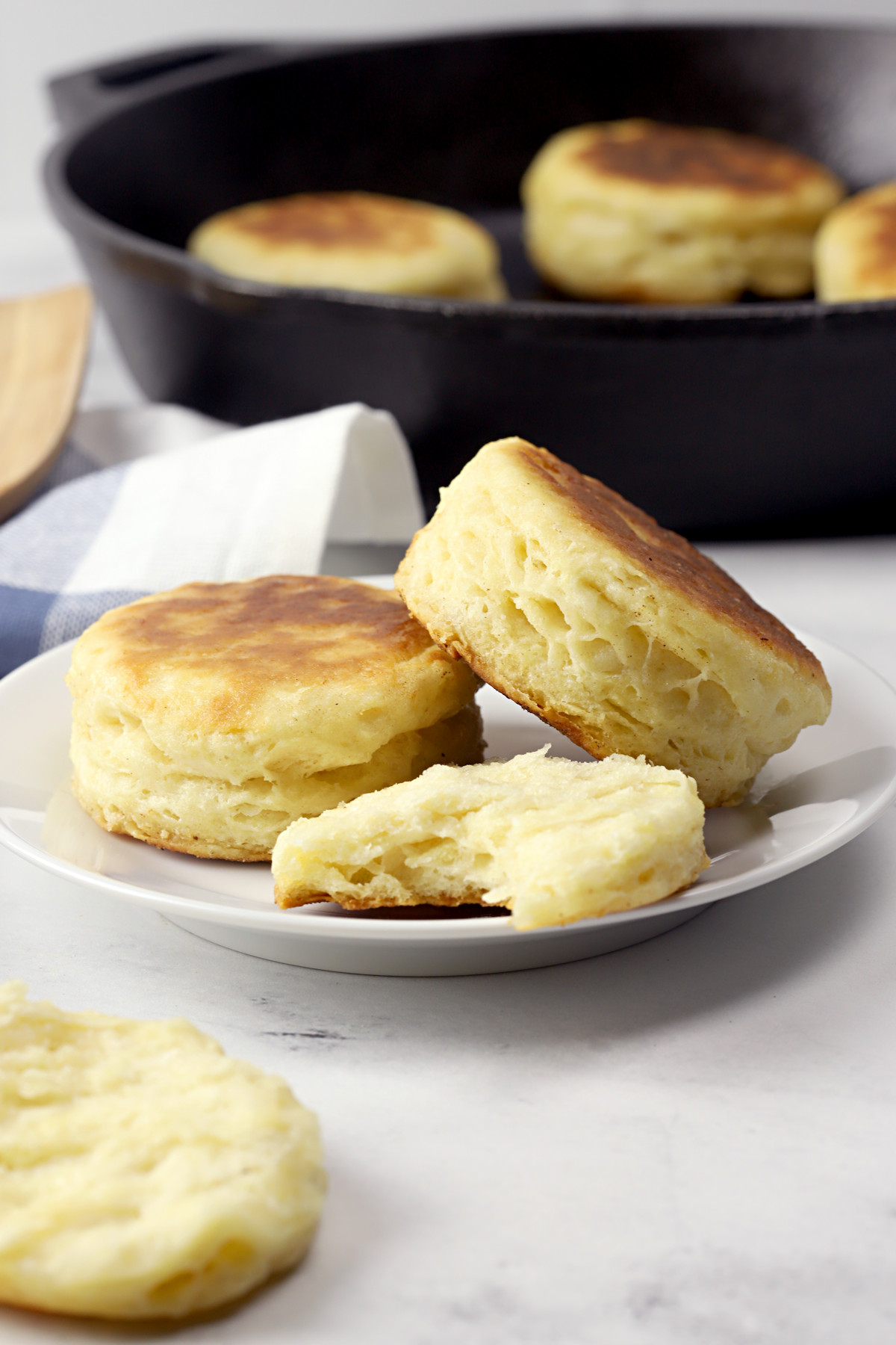 Biscuits on a plate with skillet in the background.