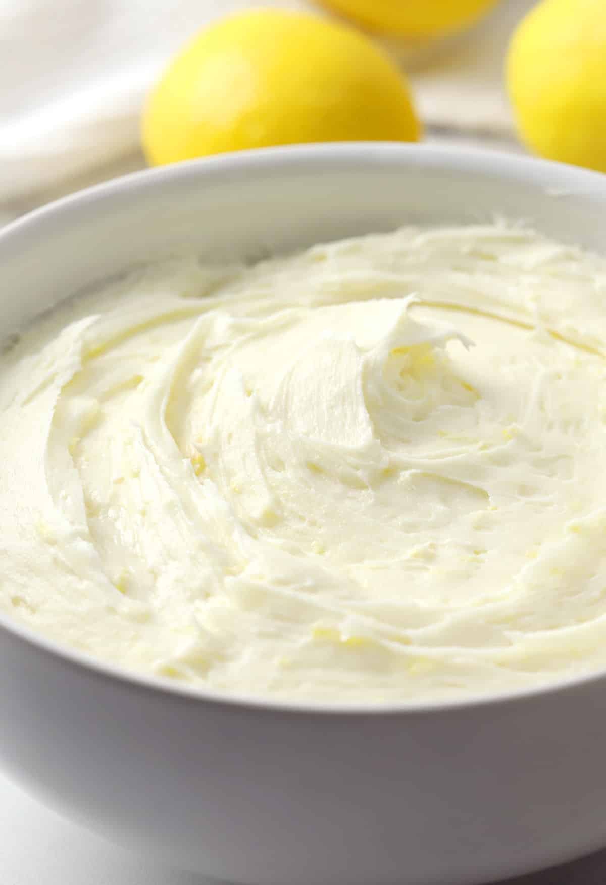 Lemon cream cheese frosting in a white bowl.