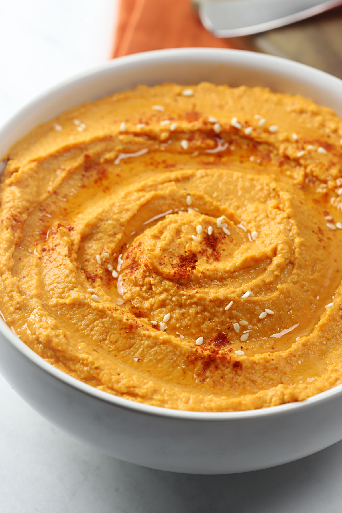 Paprika and olive oil drizzled on top of a bowl of hummus.