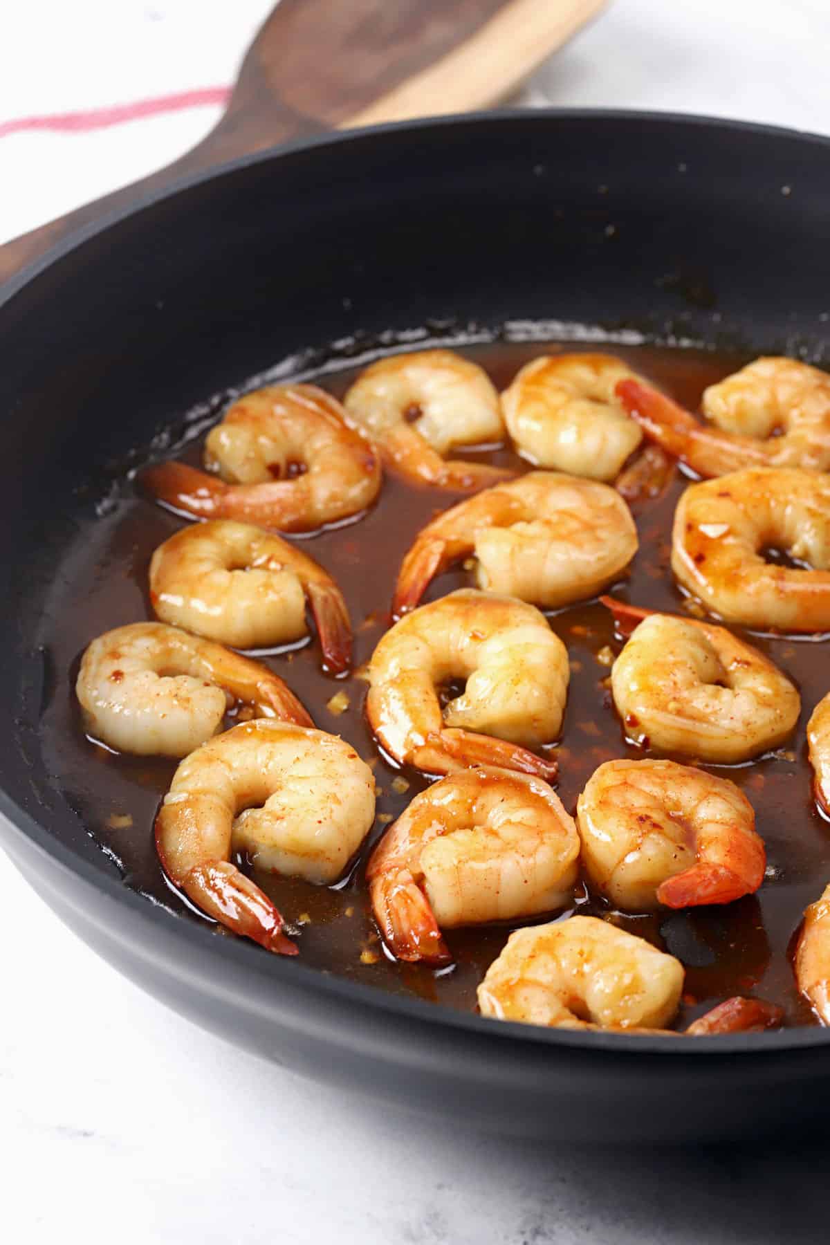 Spicy honey shrimp with sauce in a skillet.