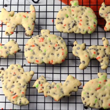 Halloween shaped cut out cookies on a cooling rack.