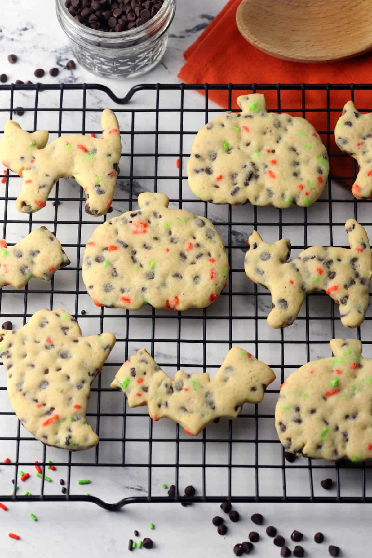 Halloween shaped cut out cookies on a cooling rack.