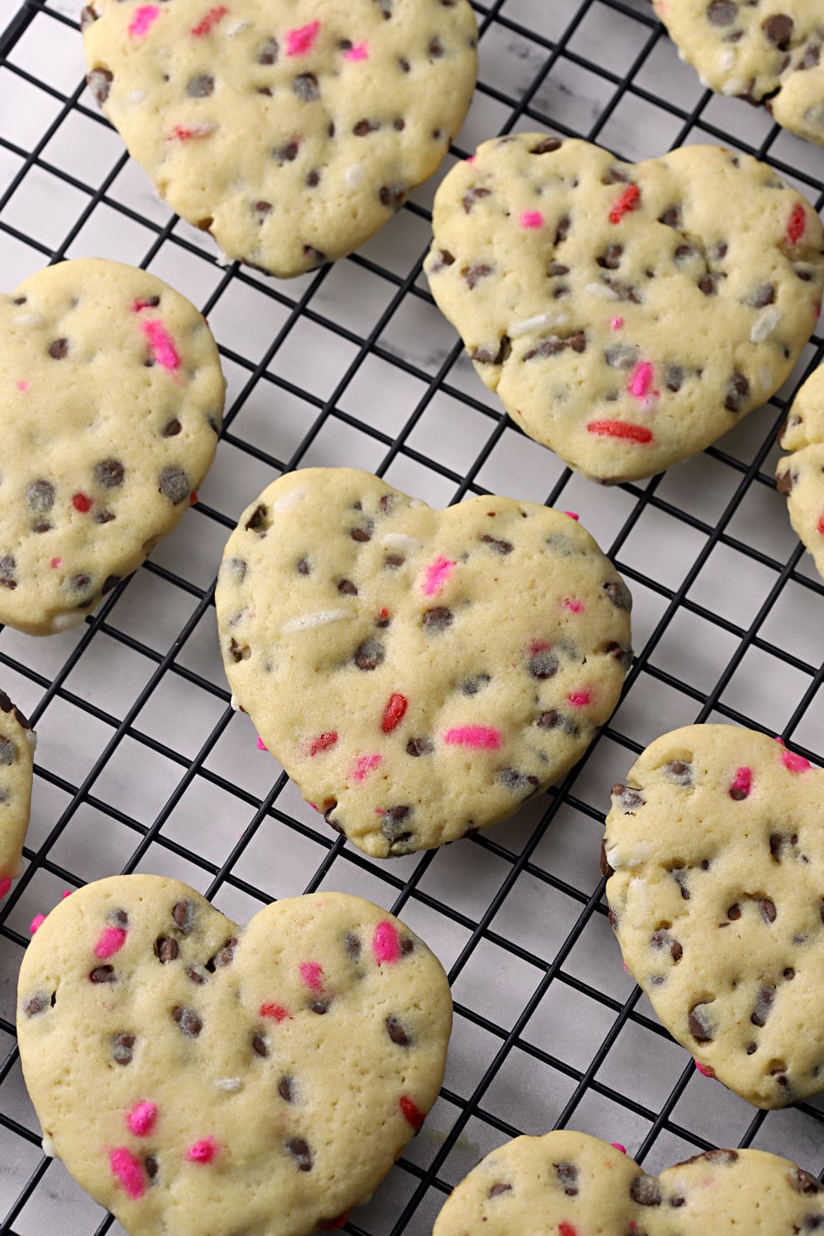 Heart shaped cookies on a cooling rack.