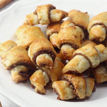 White plate filled with cinnamon pecan rugelach cookies.