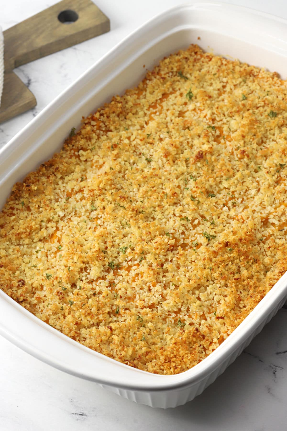 White casserole dish filled with baked sweet potato casserole.