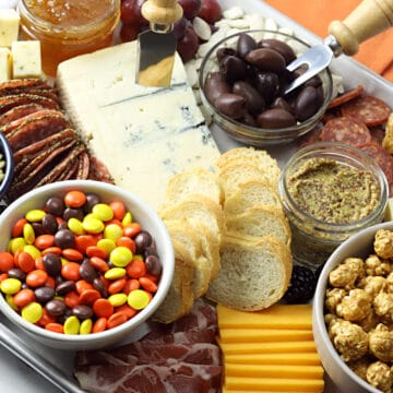 Close up of meats, cheeses, crackers, caramel corn, and candies on a Halloween charcuterie board.