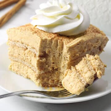 A fork with a slice of pumpkin icebox cake on a white plate.