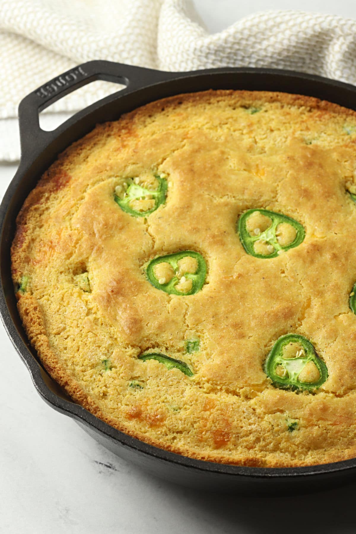 A cast iron skillet filled with jalapeno cornbread.