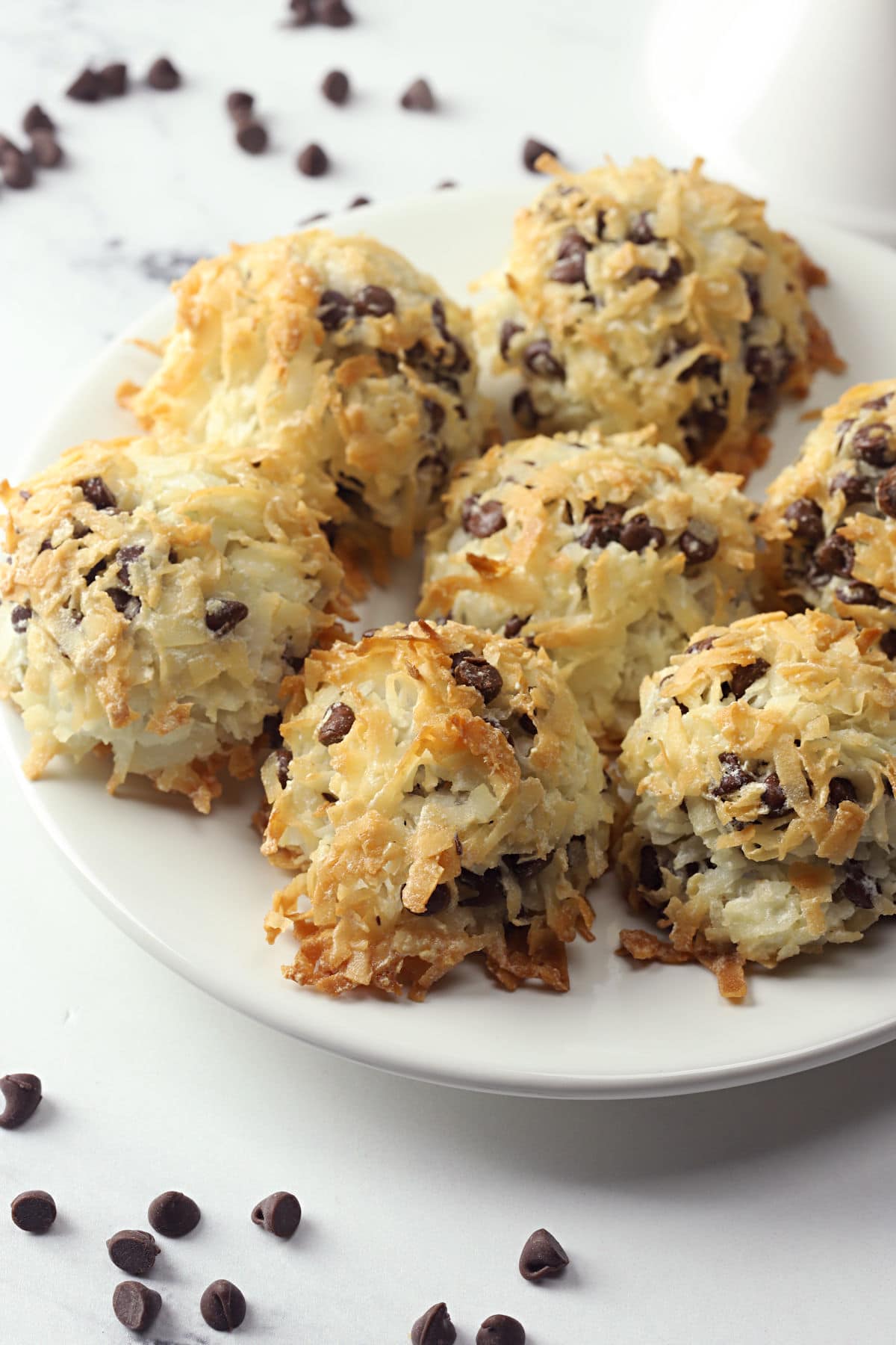 A small white plate filled with chocolate chip coconut macaroons.