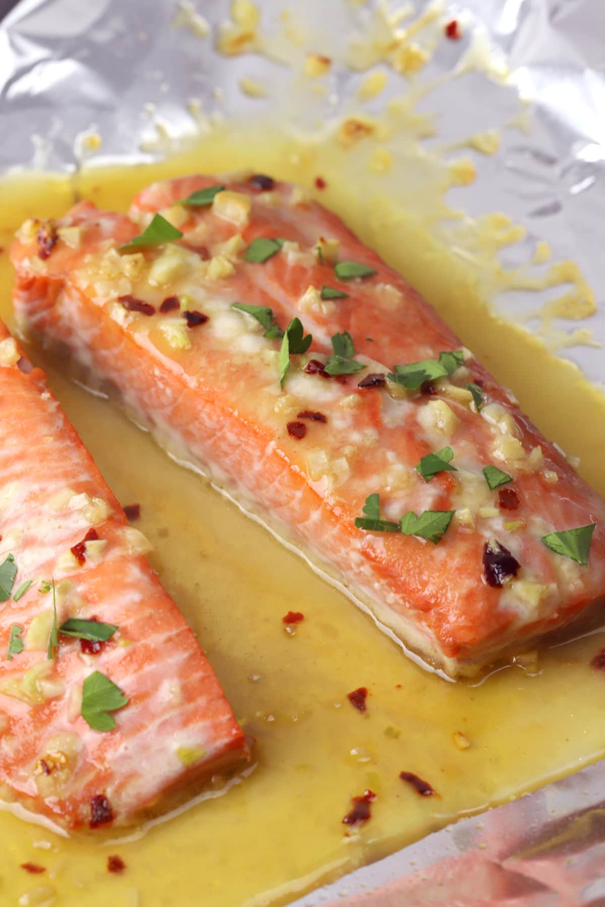 Baked salmon fillets with butter sauce on foil.