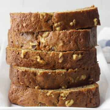 A stack of banana nut bread slices on a white plate.