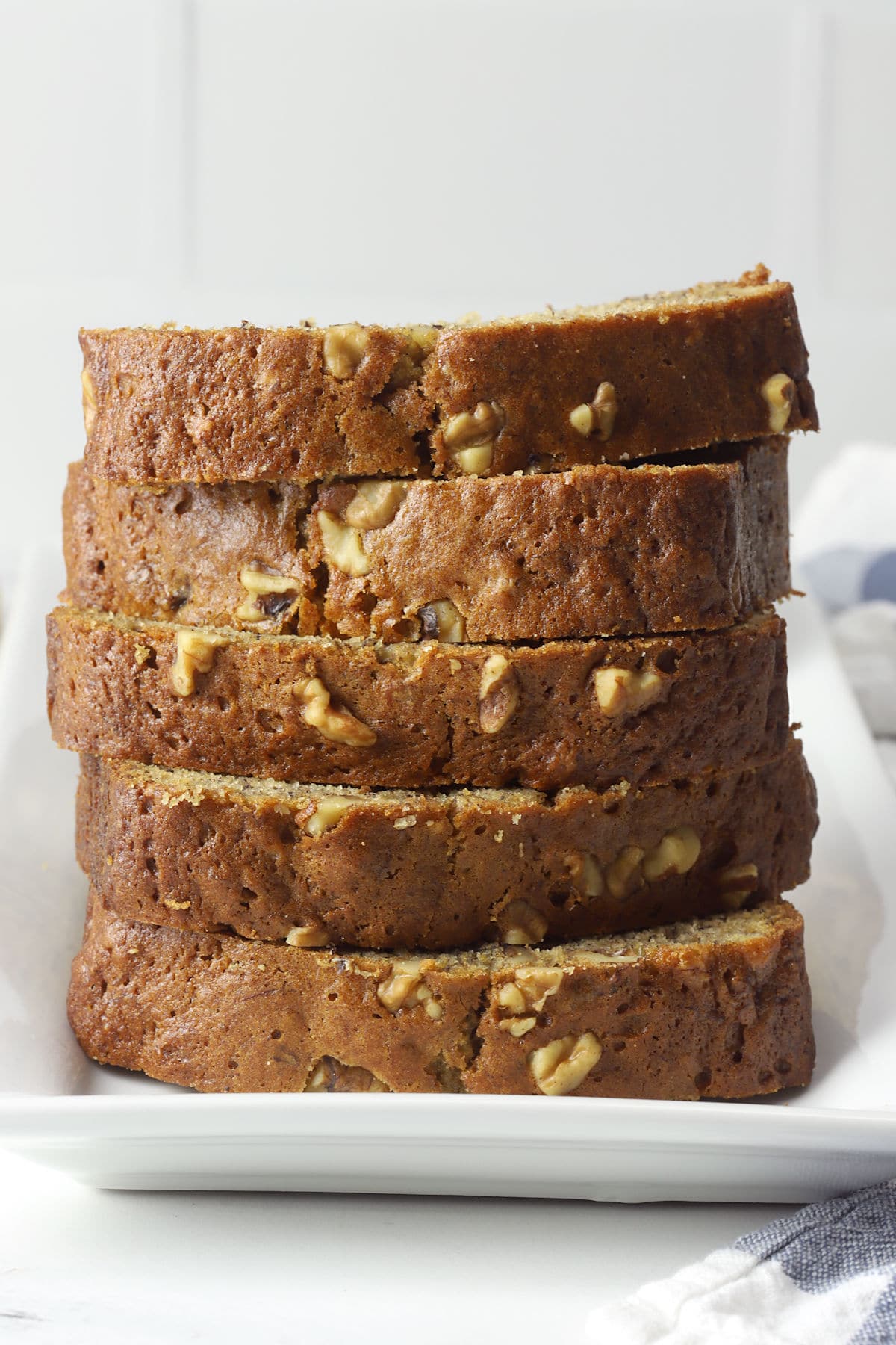 A stack of banana nut bread slices on a white plate.