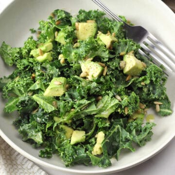 Bowl filled with kale and cubed avocado.