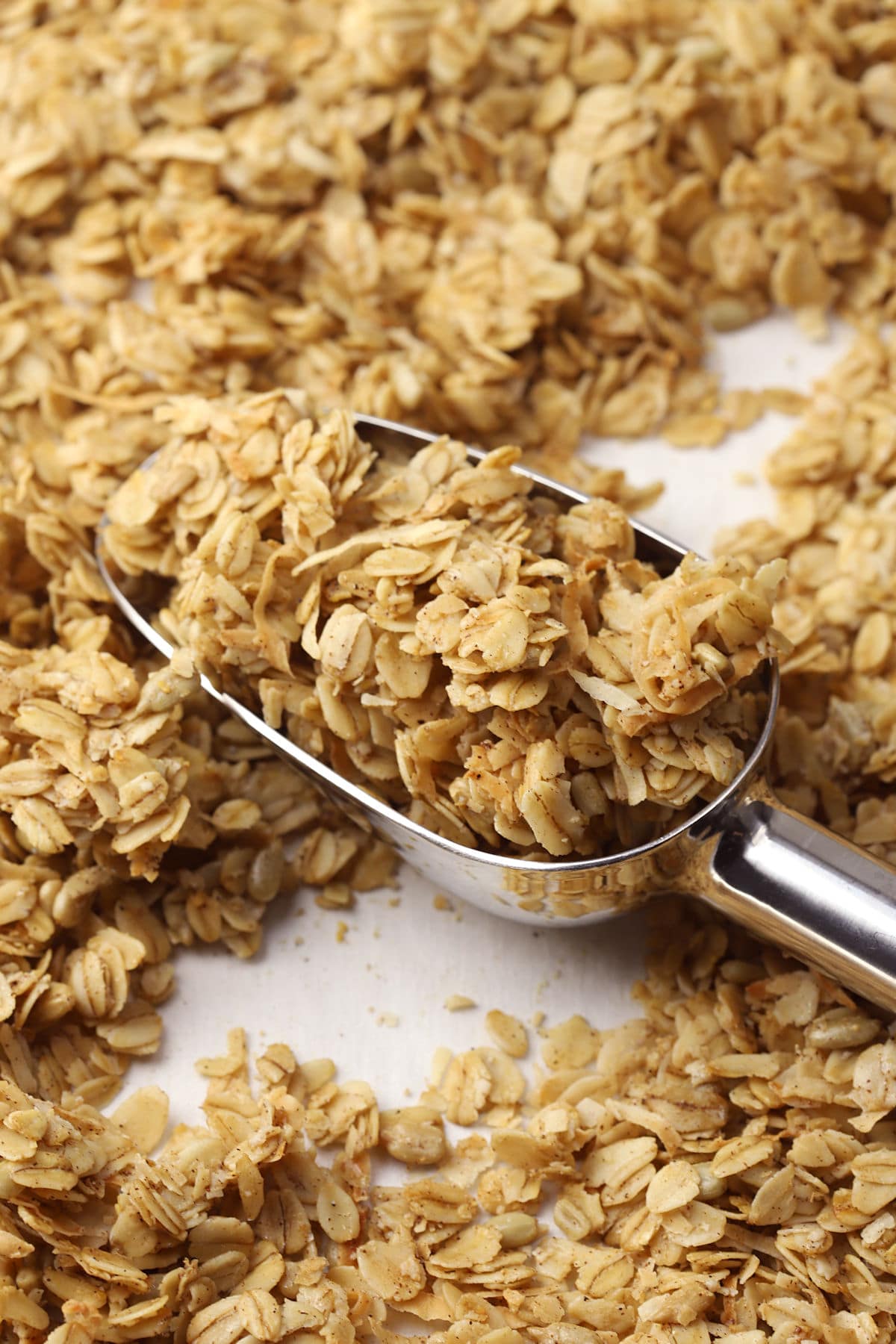 Metal scoop filled with coconut granola.