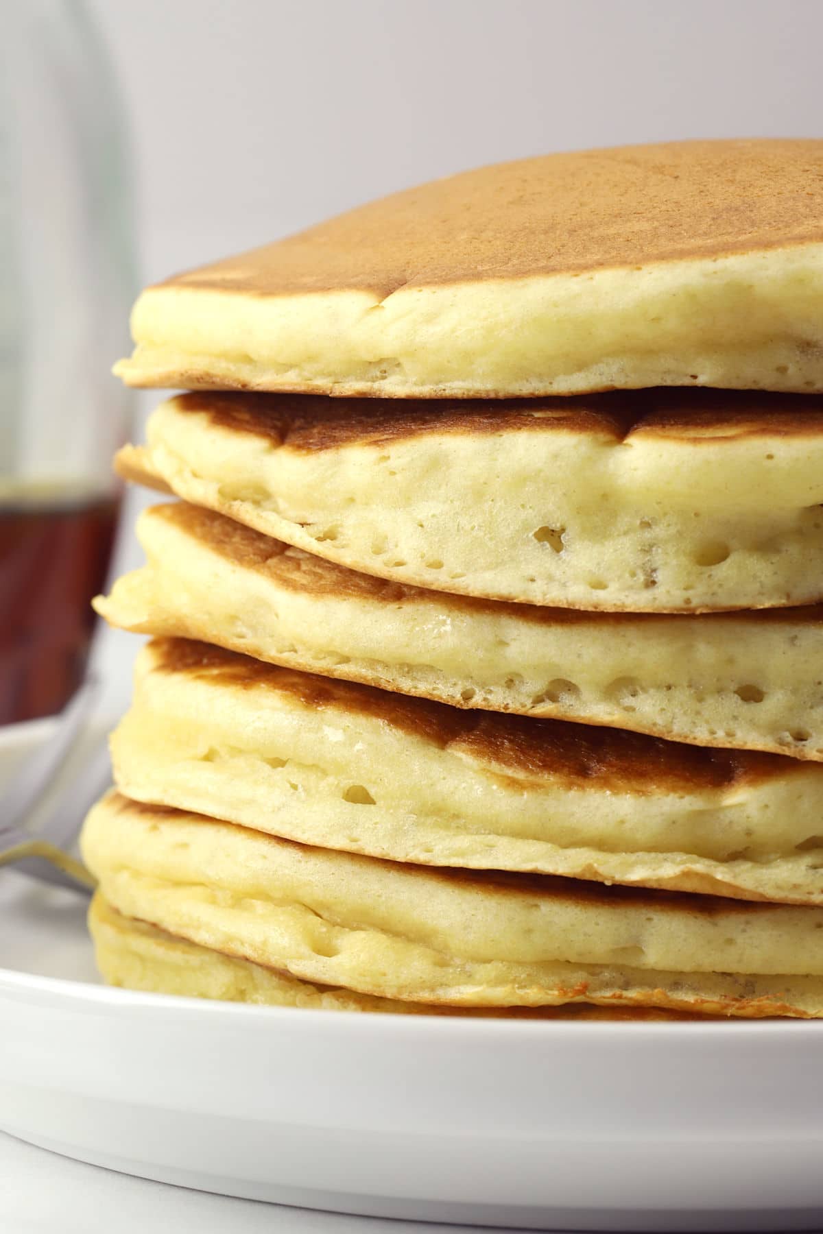 Stack of buttermilk pancakes on a white plate.