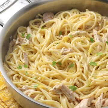 Saute pan filled with chicken and spaghetti in a cream sauce.