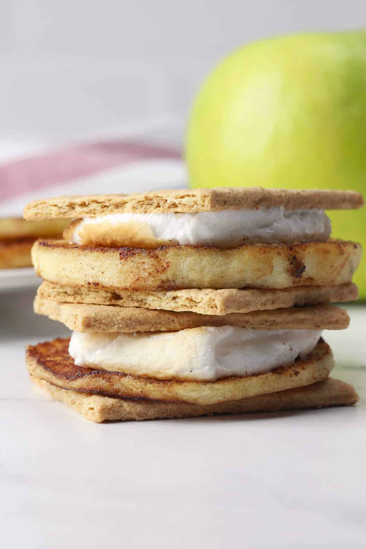 Two grilled apple s'mores stacked on top of each other.