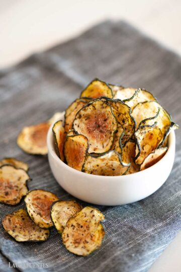 White bowl filled with zucchini chips.