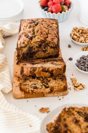 A loaf of chocolate chip zucchini bread sliced on a cutting board.