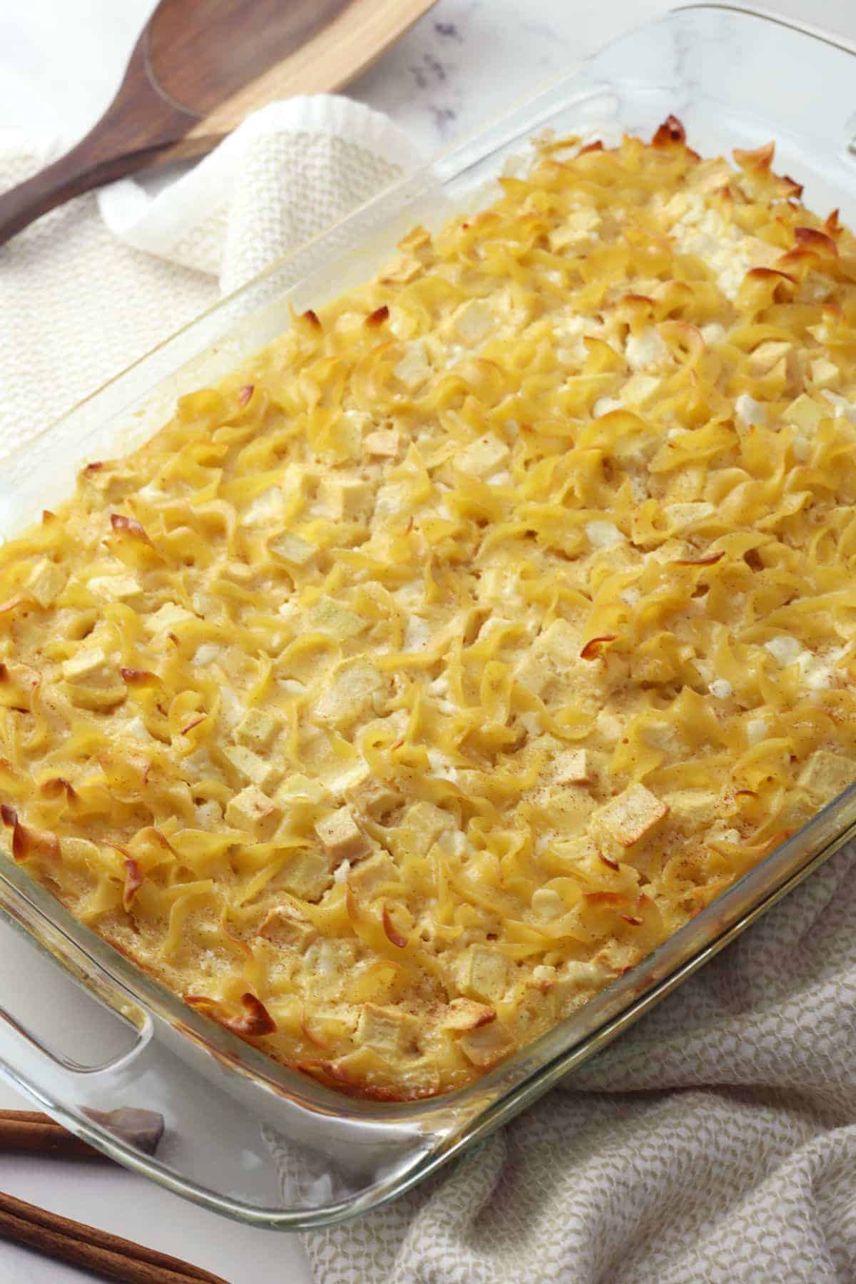 Glass casserole dish filled with sweet noodle kugel.