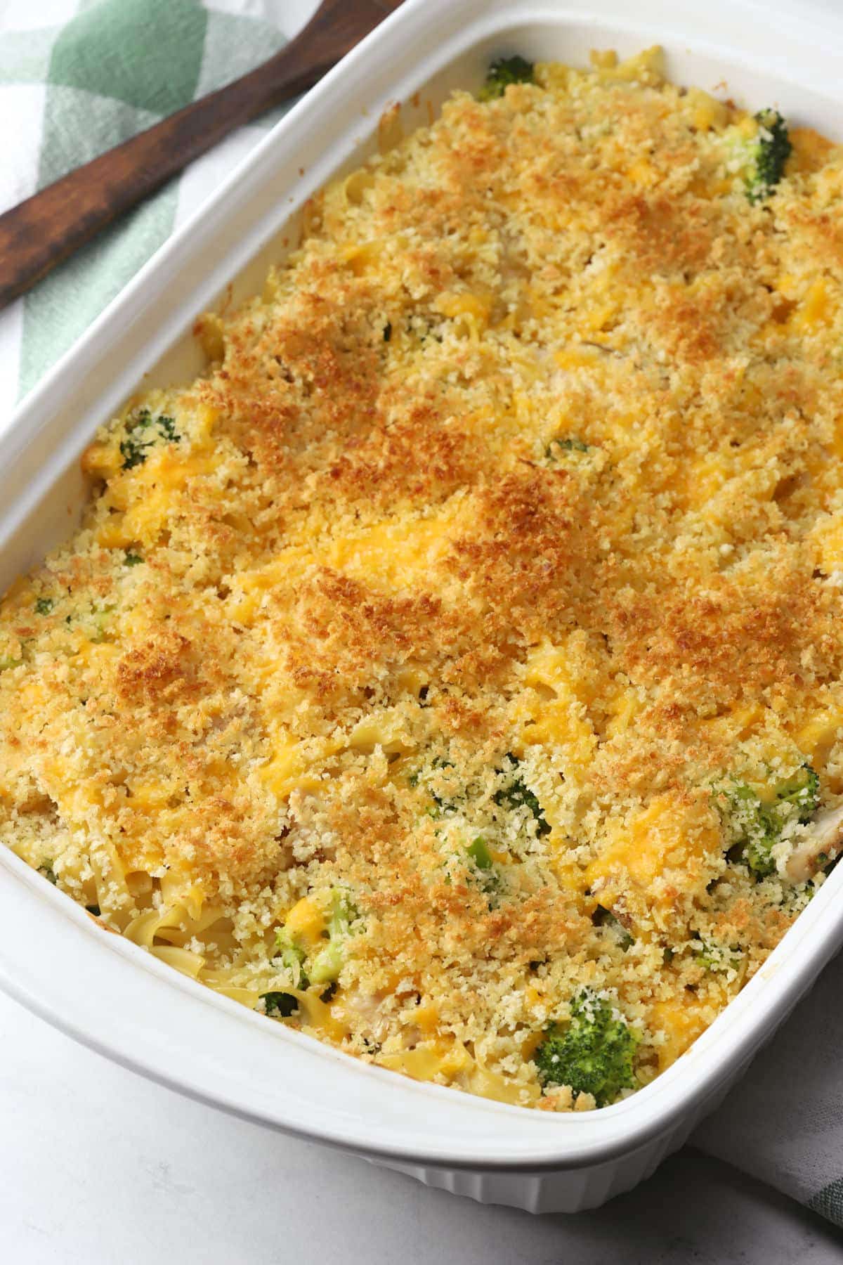 A white casserole dish filled with broccoli casserole.