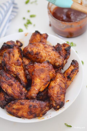 BBQ chicken wings on a white serving plate.