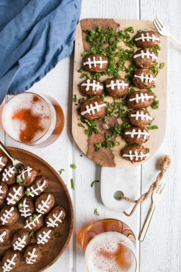 Halved potatoes topped with sour cream to decorate them like footballs.