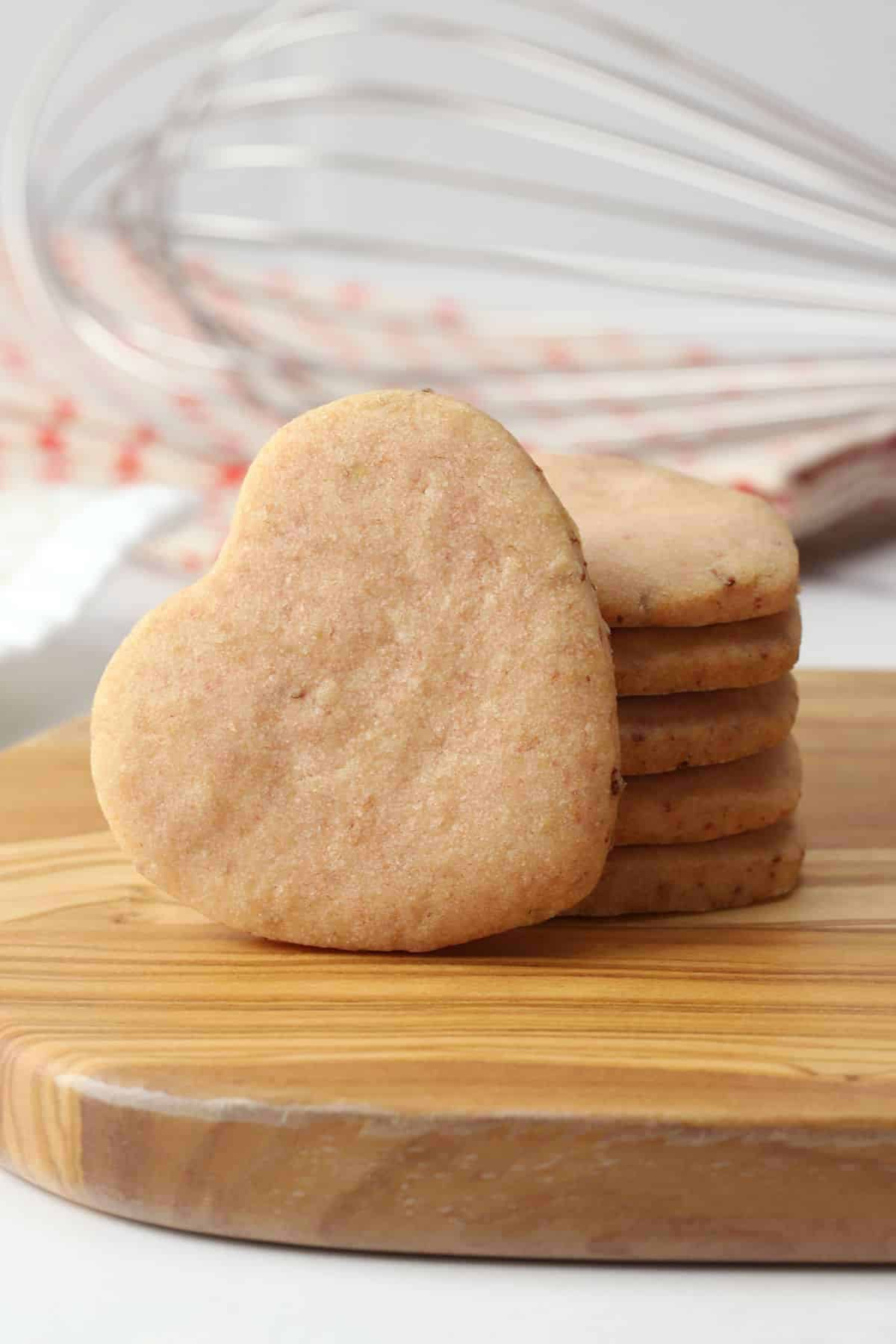 Heart shaped cookie propped up on a stack of more cookies.
