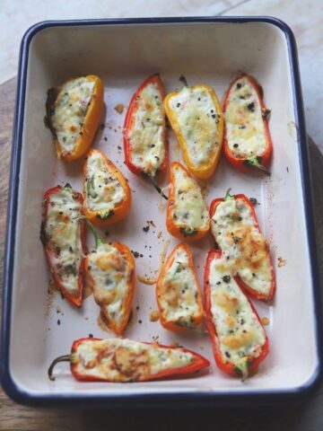 Roasted stuffed peppers in a baking pan.