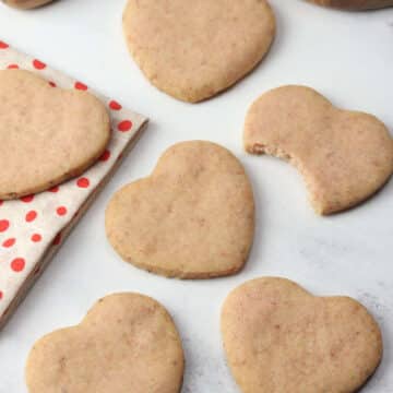 Heart shaped strawberry shortbread cookies on a countertop.