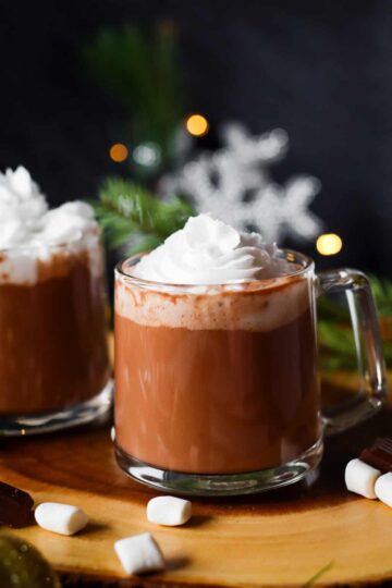 Glass mug filled with maca hot chocolate and whipped cream.