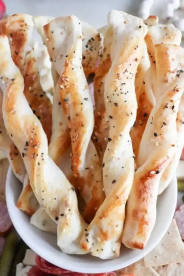A bowl holding several twisted breadsticks.