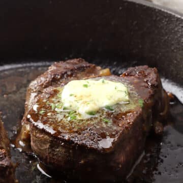 A slab of steak butter melting on top of a steak.
