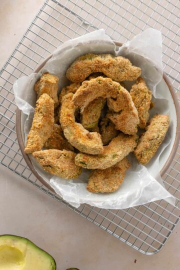 A basket of breaded and fried avocado wedges.