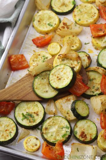 Sliced and roasted vegetables on a sheet pan.