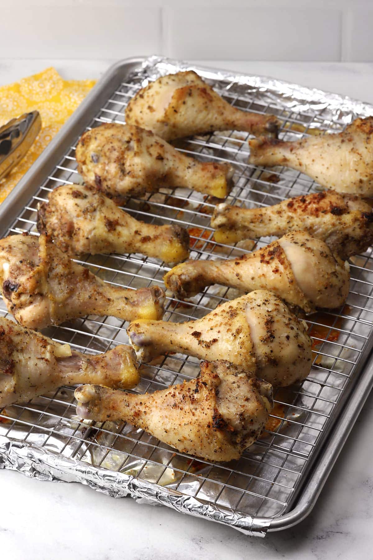 Oven roasted chicken drumsticks on a sheet pan.