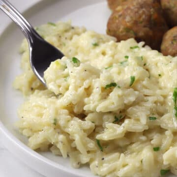 Creamy garlic parmesan rice on a fork.